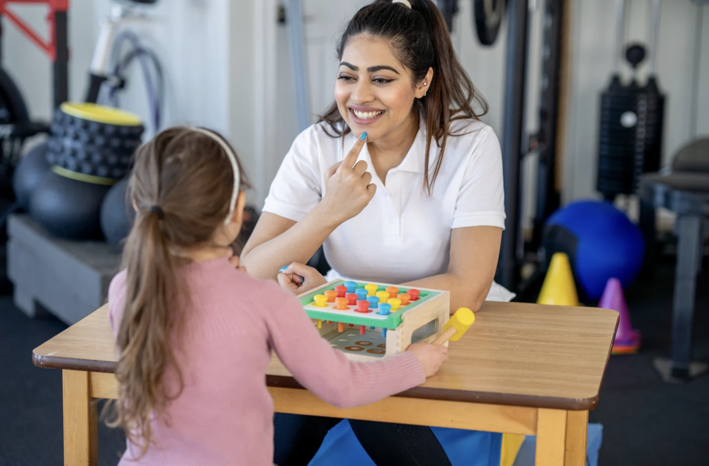 Therapist supporting a child during a hands-on learning activity