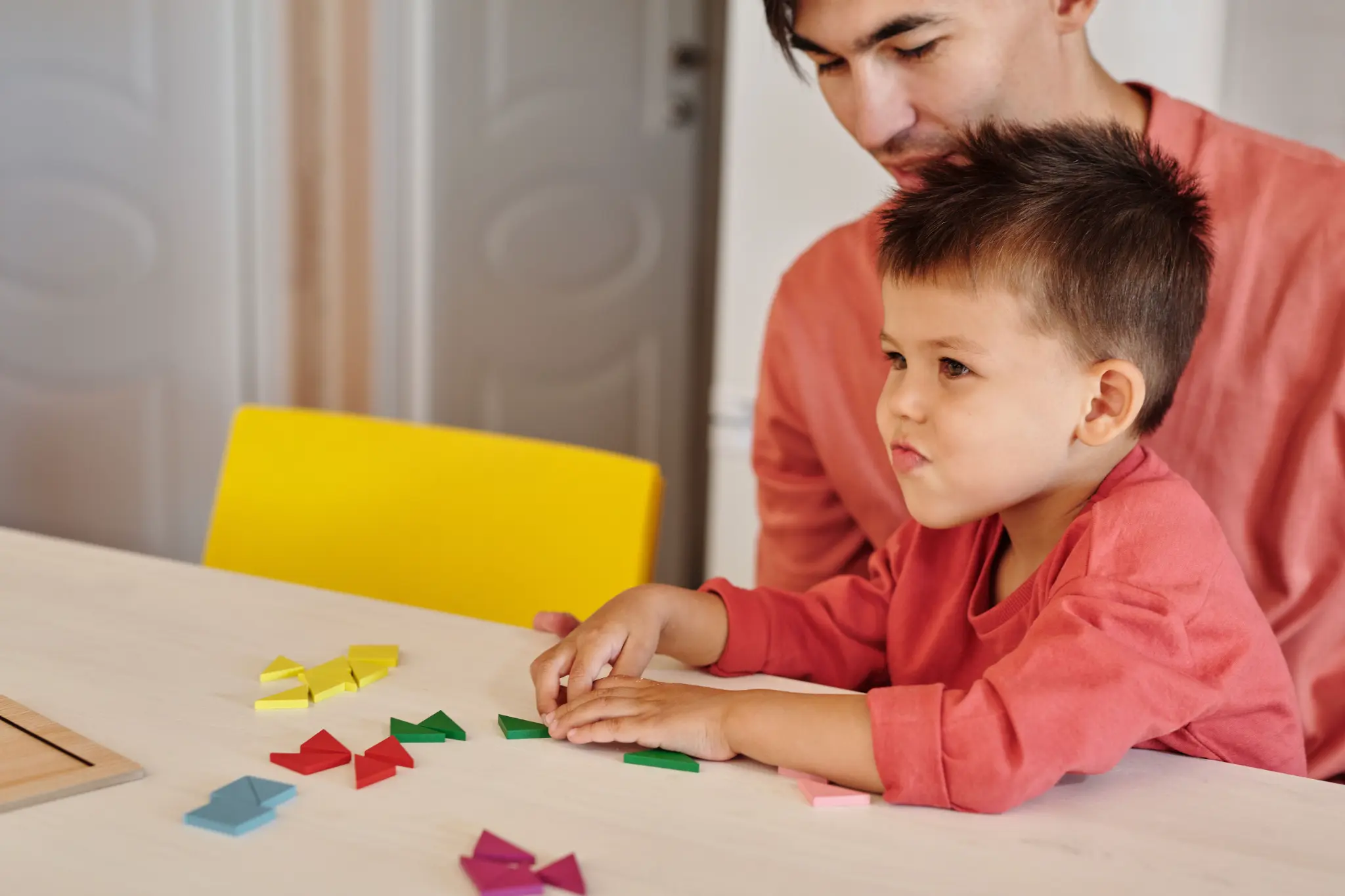Illustrative lifestyle scene of a child learning through play with a supportive adult at home